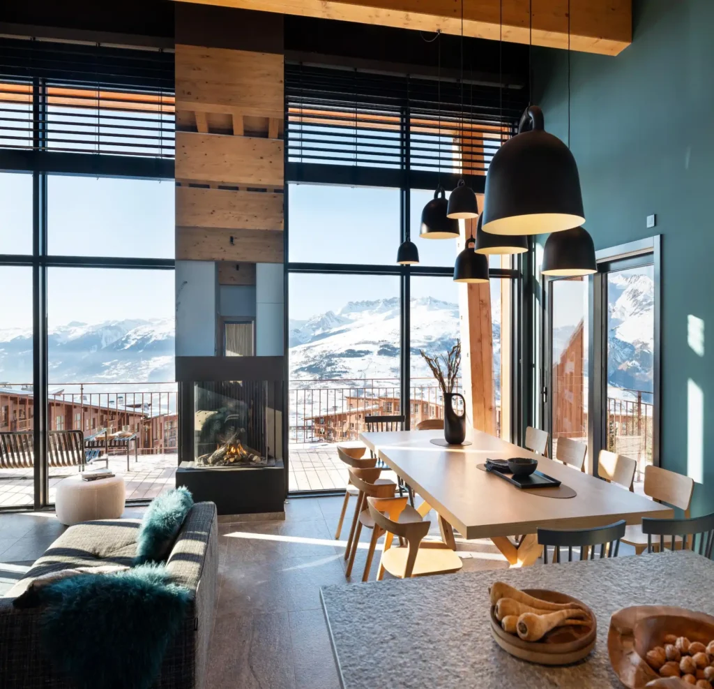 5 expériences à vivre dans un chalet de luxe dans les Alpes 3 chalet haut de gamme a louer les arcs avec une vue panoramique sur les Alpes, un salon et une table pour 12 personnes
