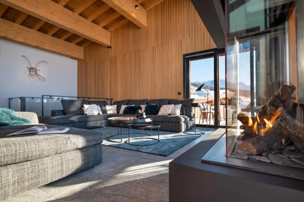 Chalet piscine : notre guide des plus beaux chalets dans les Alpes 36 salon du Chalet premium Charvet les arcs Paradiski, avec vue sur les pistes, large canapés et cheminée