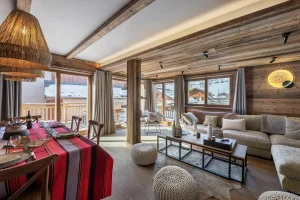 Dining area with a table laid for fondue and the lounge opening onto the terrace at Apartment Campanule in Saint-Martin-de-Belleville