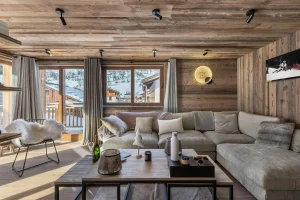 Lounge with a large corner sofa, a coffee table and a glazed door onto the balcony at Apartment Campanule in Saint-Martin-de-Belleville