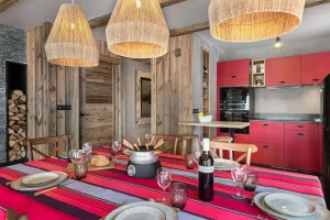 Dining room with rope pendant lights and an equipped red kitchen at Apartment Campanule in Saint-Martin-de-Belleville