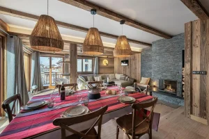 Dining room and lounge with the fireplace beyond, under reclaimed-wood beams at Apartment Campanule in Saint-Martin-de-Belleville
