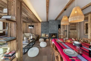 Wooden dining room with a laid table and the lounge in the background at Apartment Campanule in Saint-Martin-de-Belleville