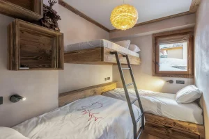Children's bedroom with wooden bunk beds and a window at Apartment Campanule in Saint-Martin-de-Belleville