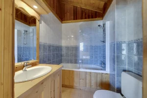 Bathroom with a bathtub, glass screen and washbasin, at Apartment des Eucherts