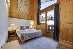 Bedroom with twin beds, a large window and grey curtain, at Apartment des Eucherts