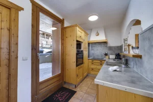 Equipped kitchen with a glazed door to the outside, at Apartment des Eucherts