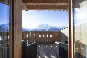 South-facing terrace with garden furniture and views of the snow-covered peaks of La Rosière, at Apartment des Eucherts