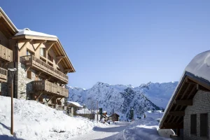 Chalets du Kandahar residence, with its stone and timber façade in the snow in La Rosière