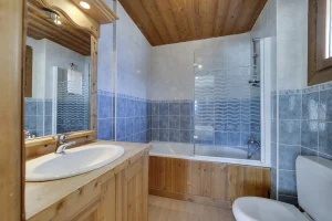 En-suite bathroom with a bathtub, washbasin and wooden vanity unit, at Apartment des Eucherts