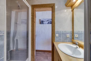 Shower room with a washbasin and blue tiles, at Apartment des Eucherts