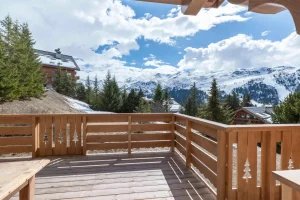 Timber balcony with a carved balustrade and a view of the Méribel ski area at Apartment Rhodos