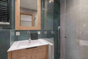 Salle de douche avec vasque et carrelage vert dans l'Appartement Rhodos