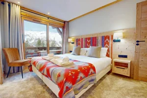 Double bedroom with a window onto the balcony and a colourful bedspread at Apartment Rhodos