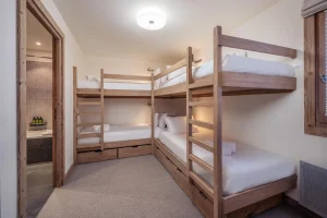 Children's bedroom with four wooden bunk berths at Chalet Alisier in Méribel Village
