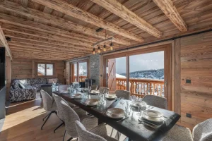 Laid table in the dining room under reclaimed-wood beams at Chalet Arnica in Les Saisies