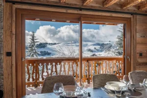 Laid table facing the picture window and the mountain view at Chalet Arnica in Les Saisies