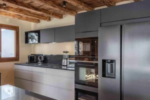 Kitchen with an American-style fridge, a built-in oven and a wine cellar at Chalet Arnica in Les Saisies