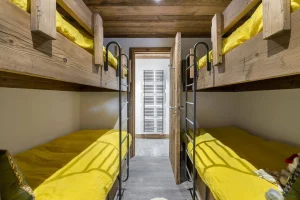 Children's bedroom with two sets of wooden bunk beds at Chalet Bouleau in Méribel