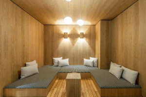Wood-panelled relaxation area with banquette seating and cushions at Chalet Brigues in Courchevel Le Praz