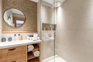 Bathroom with a wooden vanity unit, a walk-in shower and bathrobes at Chalet Brigues in Courchevel Le Praz