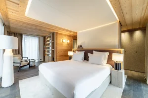 Master suite with a seating corner, a floor lamp and a dressing area at Chalet Brigues in Courchevel Le Praz