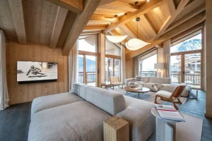 TV lounge with a sofa, an armchair and a wall-mounted screen facing the view at Chalet Brigues in Courchevel Le Praz