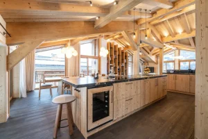 Kitchen island with a refrigerated wine cellar and stools at Chalet Brigues in Courchevel Le Praz