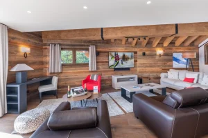 Reclaimed-wood lounge with leather sofas, a desk and a TV at Chalet du Plantin in Méribel Village
