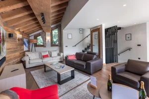Lounge with sofas, a coffee table and the staircase to the upper floors at Chalet du Plantin in Méribel Village