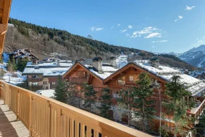Timber balcony overlooking the chalets of Méribel Village and the peaks at Chalet du Plantin in Méribel Village