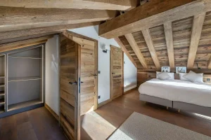 Master bedroom with a dressing room and exposed beams at Chalet du Plantin in Méribel Village