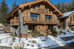 Chalet du Plantin from outside, with a timber terrace and log store in Méribel Village