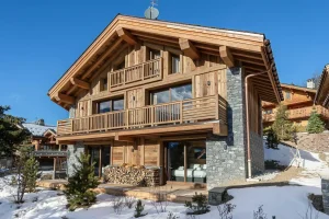 Timber and stone chalet façade with balconies in the snow in Méribel Village