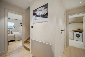 Corridor and staircase serving the bedrooms, with the laundry room beyond at Chalet Églantine in Courchevel La Tania