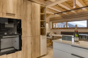 Equipped kitchen with a built-in oven and light wood units at Chalet Épicéa in Les Saisies