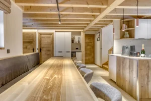 Dining table and open kitchen seen from the banquette at Chalet Épicéa in Les Saisies