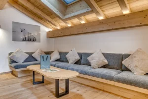 Lounge with a corner banquette, a wooden coffee table and a roof window at Chalet Épicéa in Les Saisies