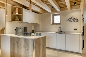 Kitchen with a central island, a white worktop and a marble splashback at Chalet Épicéa in Les Saisies