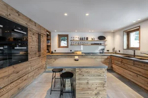 Semi-professional reclaimed-wood kitchen with a central island and built-in ovens at Chalet Merlin in Saint-Martin-de-Belleville