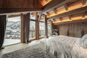 Master suite with picture windows opening onto the balcony and the mountain view at Chalet Merlin in Saint-Martin-de-Belleville