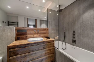 Bathroom with an oval washbasin, a reclaimed-wood vanity unit and a bathtub at Chalet Merlin in Saint-Martin-de-Belleville