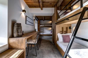 Bunk-bed room with a desk and reclaimed-wood bunks