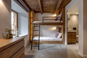 Bunk beds with a ladder in a room with a dresser