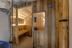 Sauna with pale wood benches behind a glass door