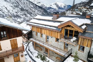 Chalet Villette in the snow, a stone and timber building with a balcony